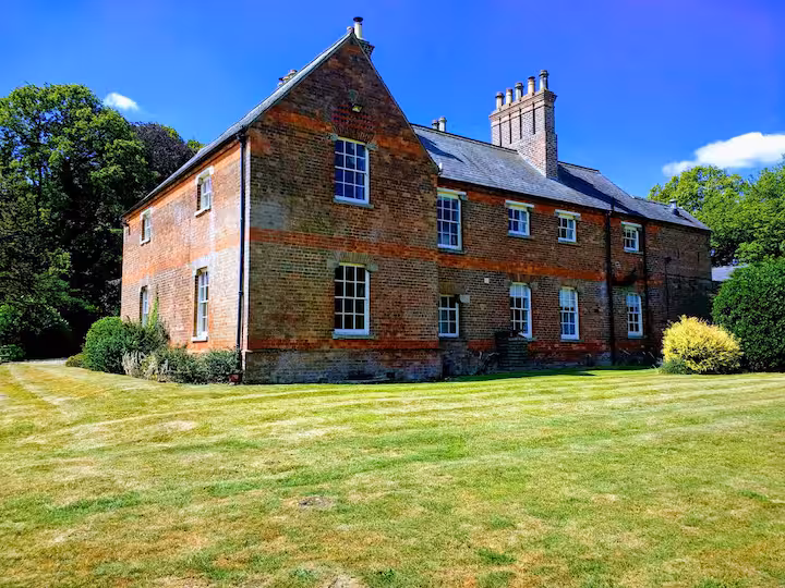 The exterior of Lusby Manor surrounded by lawn and trees